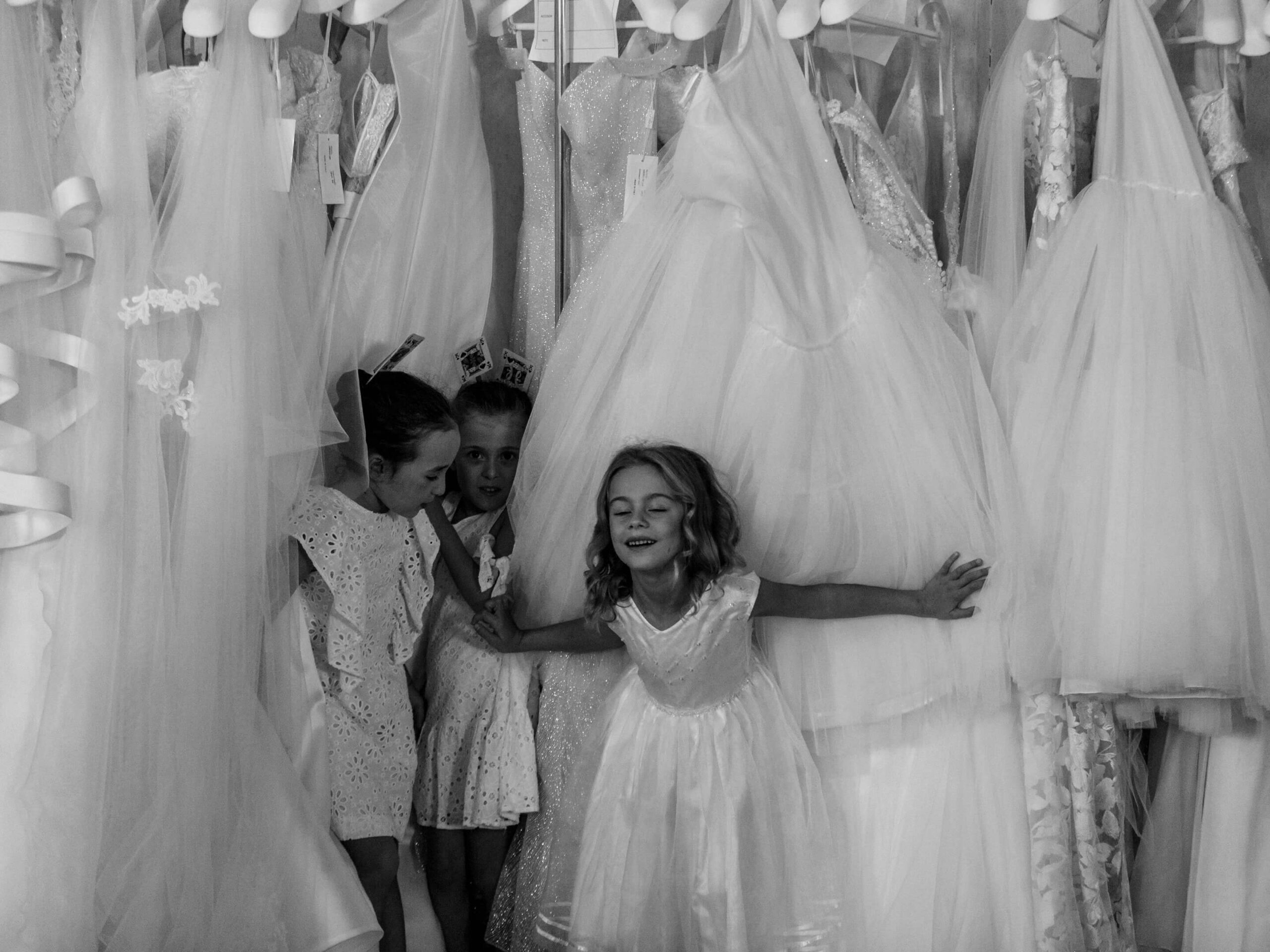 bambine giocano tra gli abiti da sposa